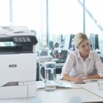 Zwei Frauen arbeiten in einem Büro neben einem Xerox® VersaLink® C625 Farb-Multifunktionsdrucker